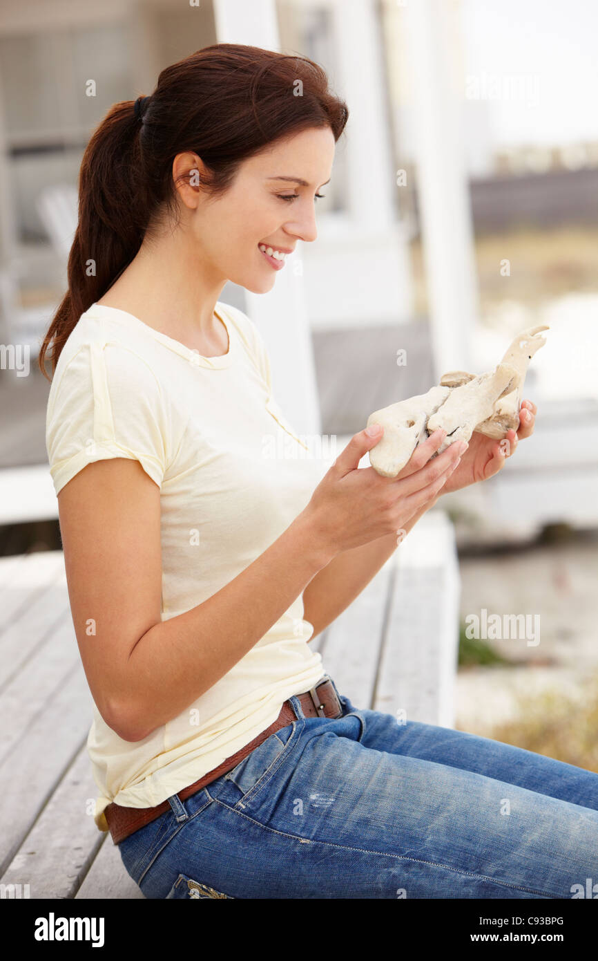 Femme assise en plein air holding starfish Banque D'Images