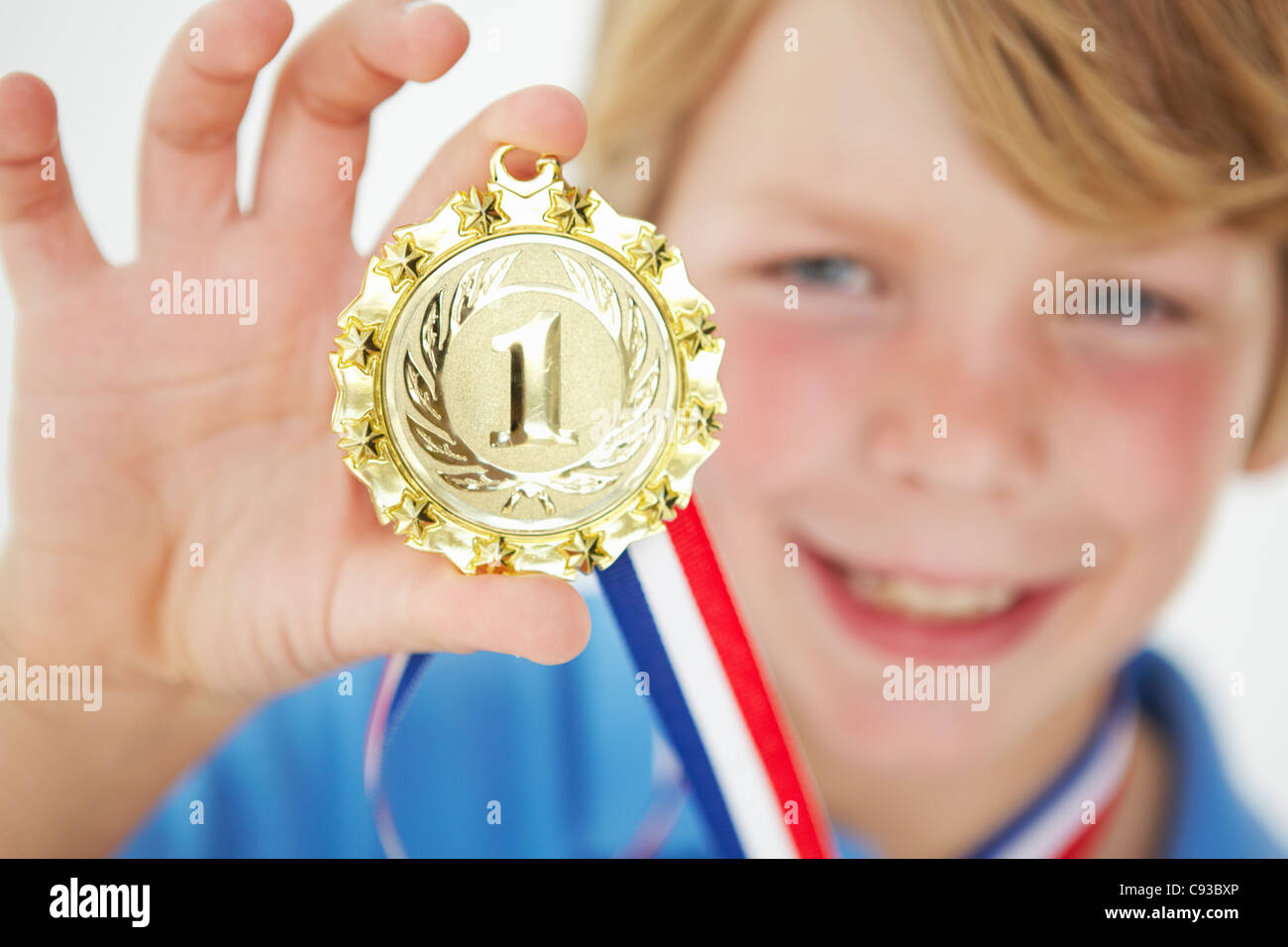 Jeune garçon exhibant medal Banque D'Images