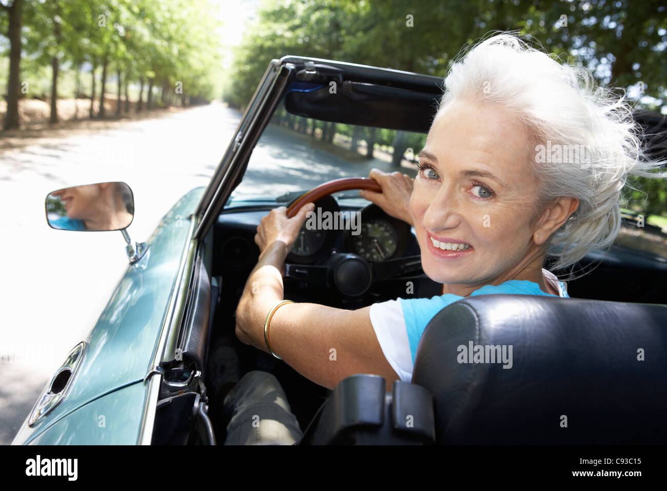 Senior woman in sports car Banque D'Images