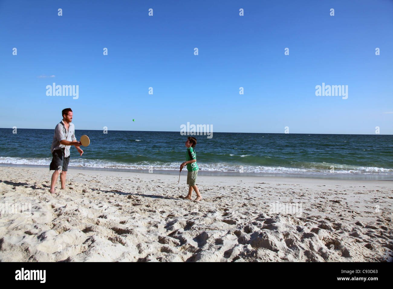 Homme et enfant jouant kadima paddle ball sur la plage Banque D'Images