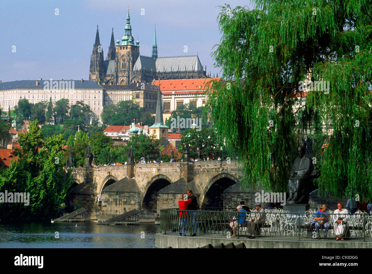 Le Pont Charles sur la Vltava avec la Cathédrale Saint Vitus' et les touristes à la Riverside restaurant à Prague Banque D'Images