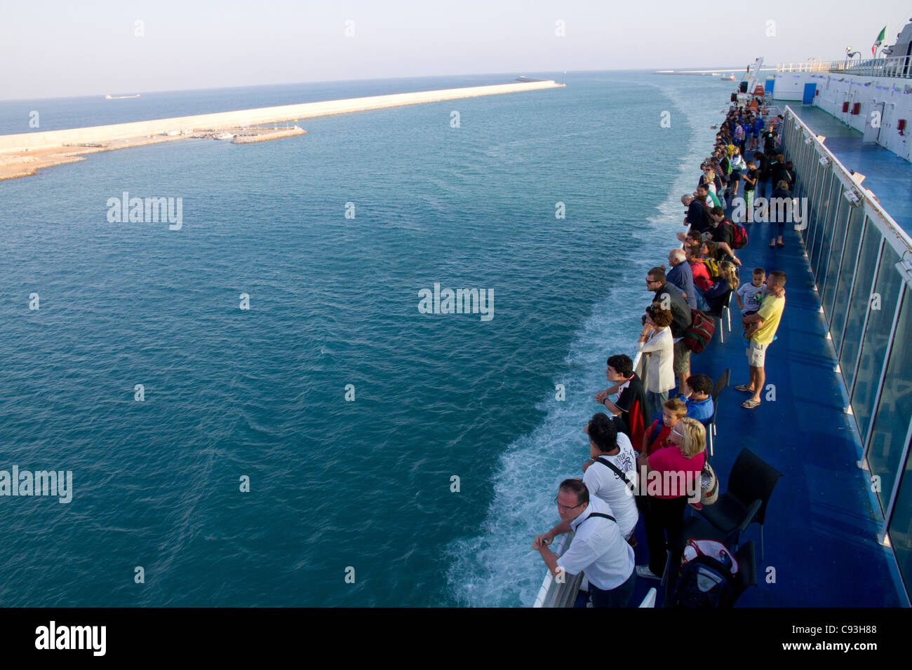 Les gens sur le pont à bord de navires transbordeurs à loin d'arriver à port Banque D'Images