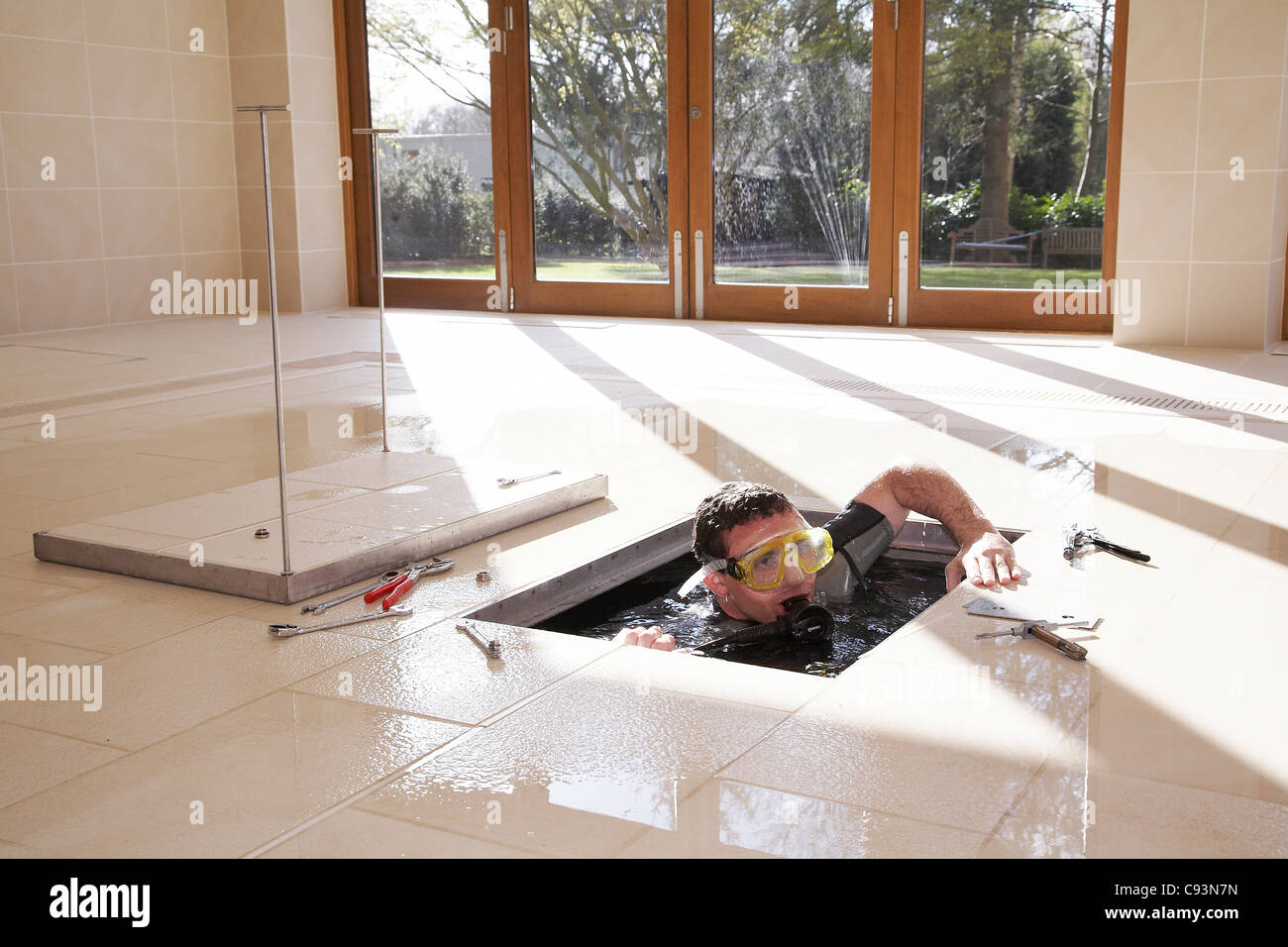 L'homme de procéder à l'entretien d'hydraulique d'un piscine avec une chaussée submersible. Banque D'Images