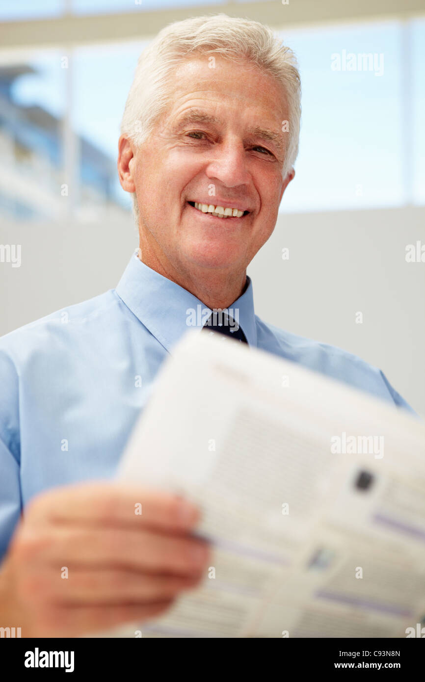 Senior businessman reading document Banque D'Images