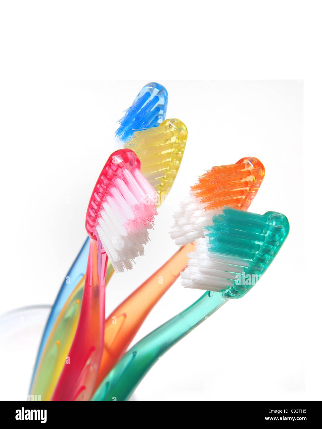 Groupe des brosses à dents multicolores dans un verre d'eau Banque D'Images