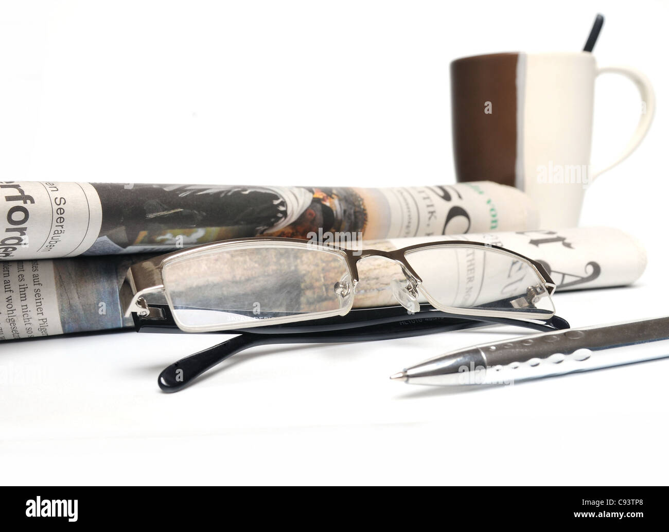 Still Life - Journal, lunettes, tasse de café et ball pen over white background Banque D'Images