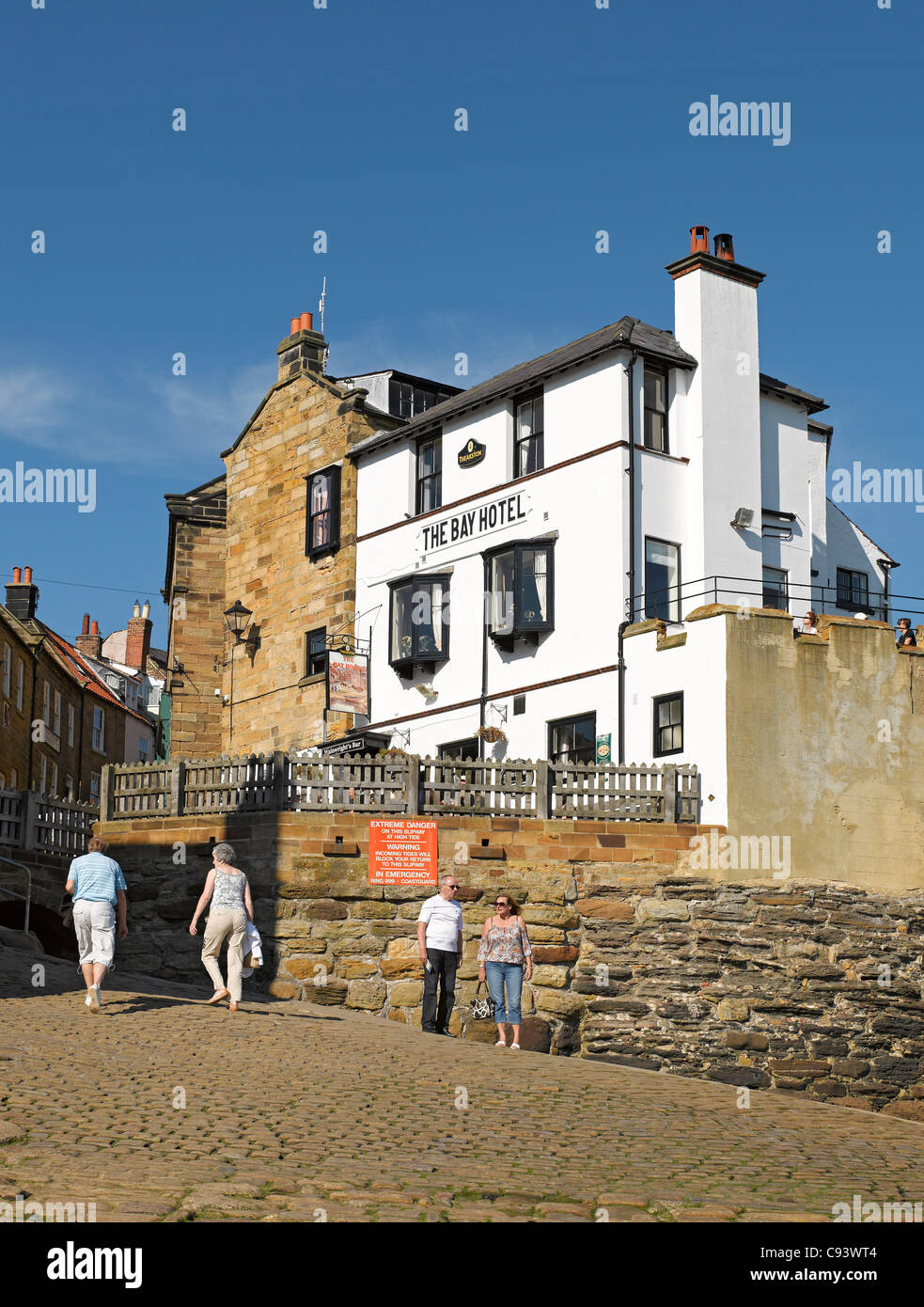 Gens touristes visiteurs à côté de l'hôtel Bay en été Robin Hottes Bay North Yorkshire Angleterre Royaume-Uni Royaume-Uni GB Great Grande-Bretagne Banque D'Images