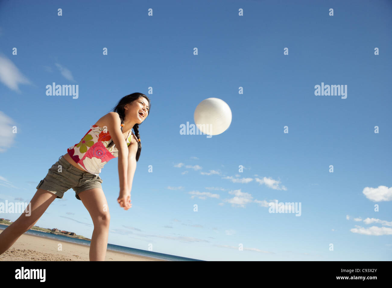 Teenage girl playing beach volleyball Banque D'Images