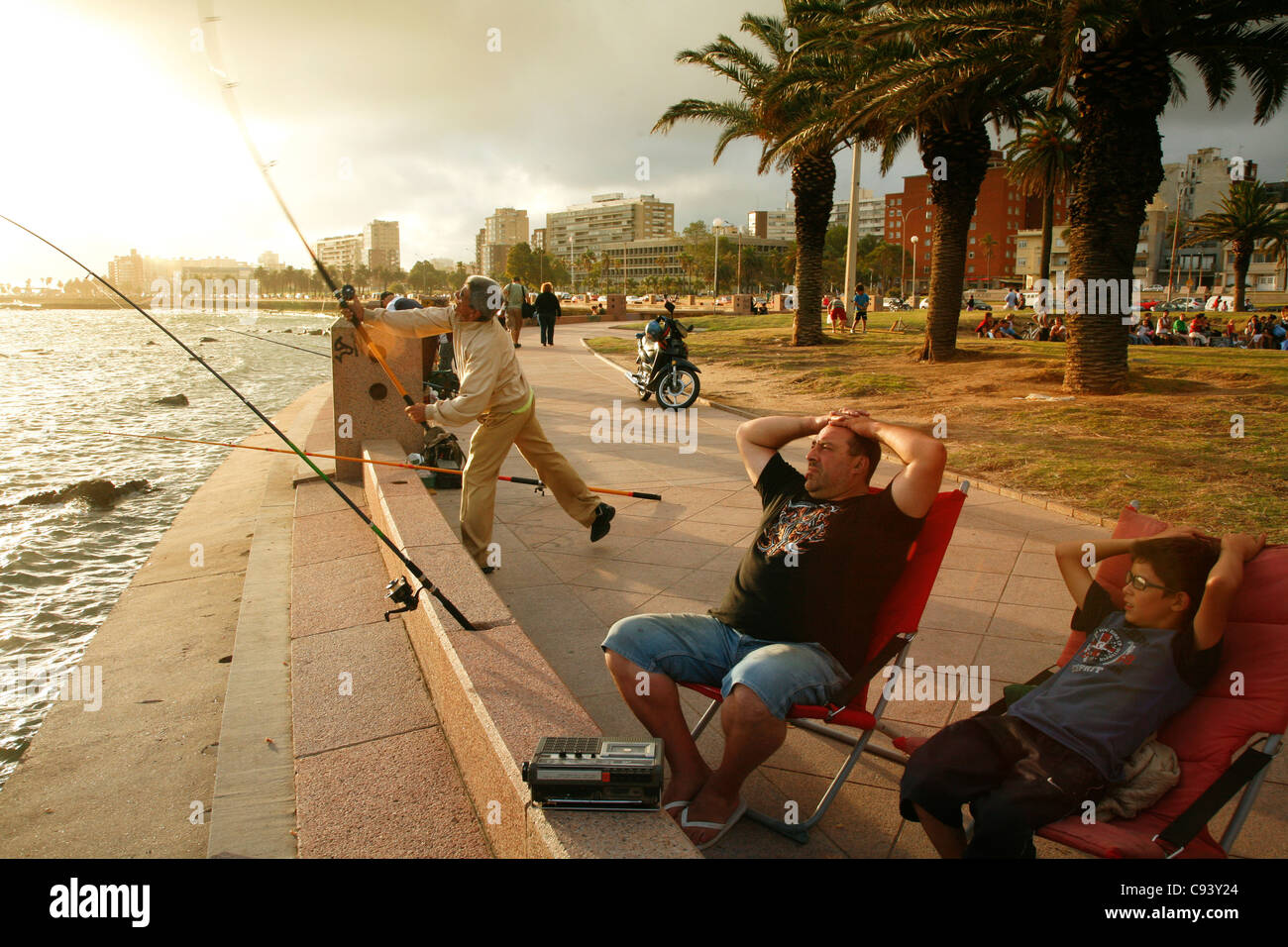 Les gens la pêche et la marche à pied le long de la Rambla, le Riverfront Promenade, Montevideo, Uruguay. Banque D'Images