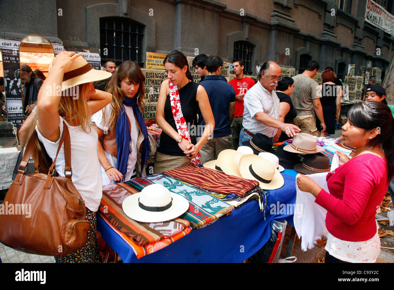 Femme essayant de chapeaux à l'Dimanche Tristan Narvaja Street Market, Montevideo, Uruguay. Banque D'Images