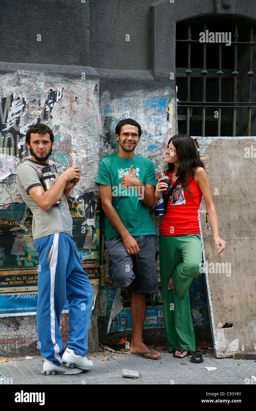 Les jeunes boivent mate au marché de rue dimanche Tristan Narvaja, Montevideo, Uruguay. Banque D'Images