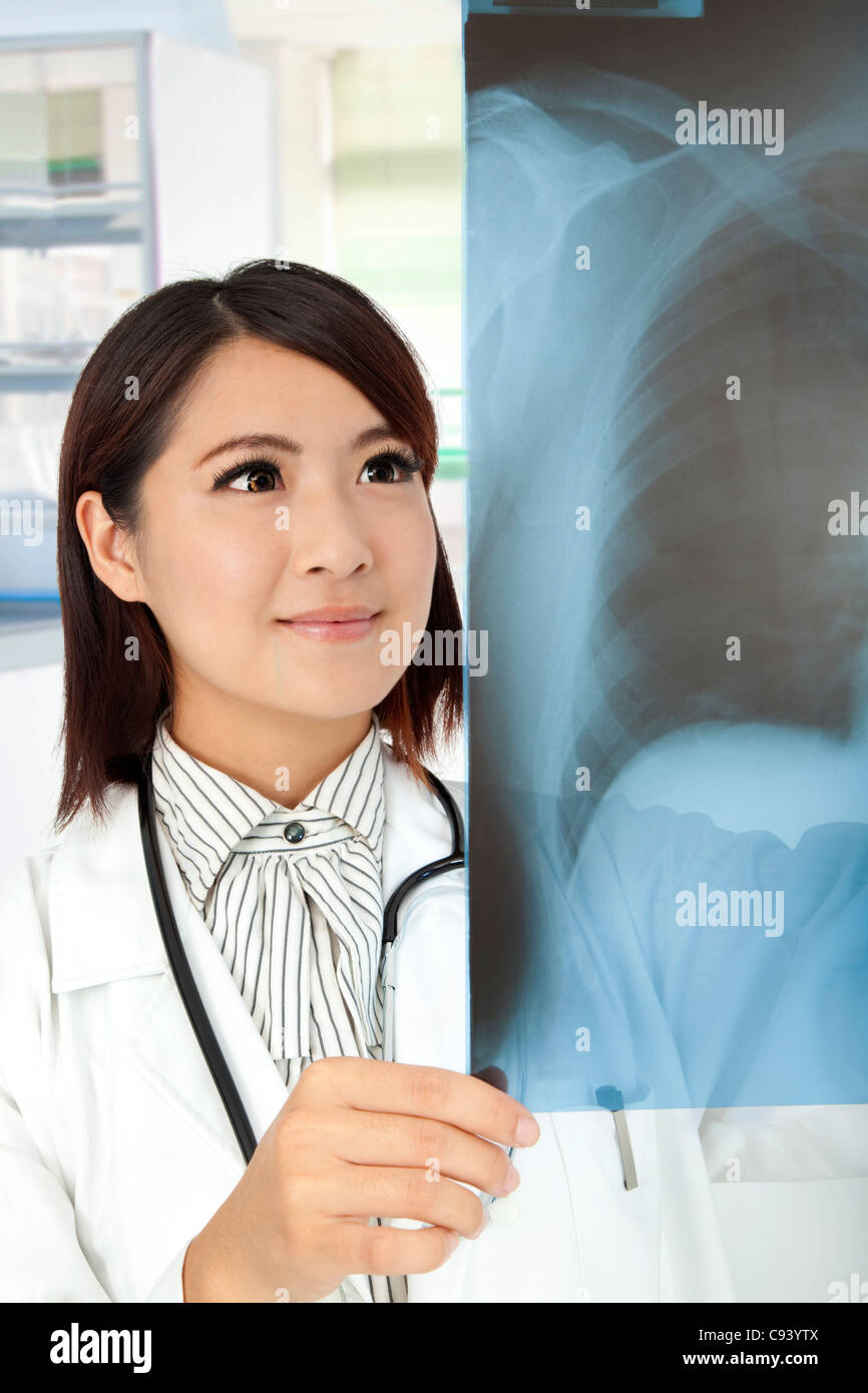 Médecin asiatique l'examen aux rayons x dans le bureau du médecin Banque D'Images