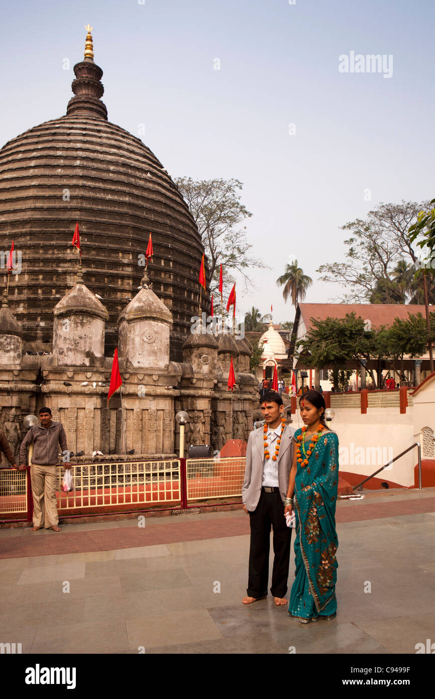 L'Inde, de l'Assam, Guwahati, temple Kamakhya, jeune couple de pèlerins, des guirlandes de fleurs en face de l'Shikara Banque D'Images