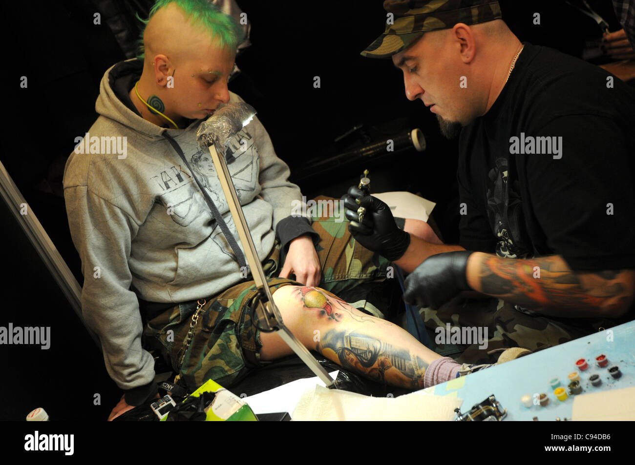 12.11.2011 Varsovie, Pologne. Tatoueur travaille avec son client au cours de la première journée de tattoo, body painting et pierceing show - Body Art 'Convention' dans un palais de la Culture et de la science à Varsovie. Banque D'Images