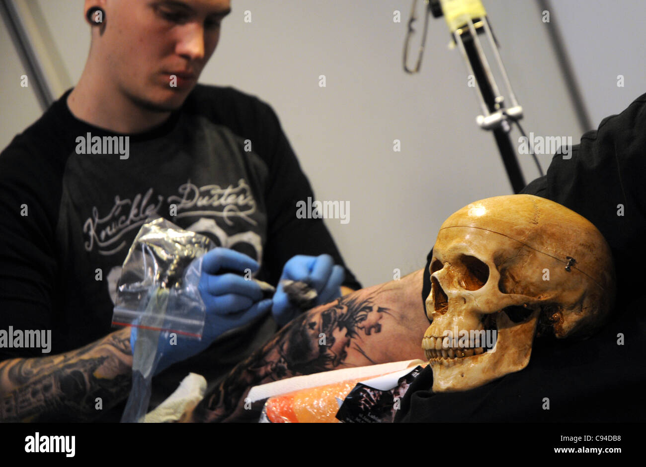 12.11.2011 Varsovie, Pologne. Tatoueur travaille avec son client au cours de la première journée de tattoo, body painting et pierceing show - Body Art 'Convention' dans un palais de la Culture et de la science à Varsovie. Banque D'Images