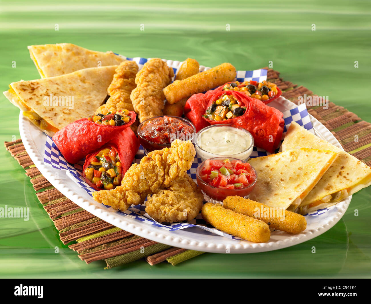 Un apéritif mixte d'ailes de poulet, quesadillas, bâtonnets de courgette et taquitos avec diverses sauces Banque D'Images