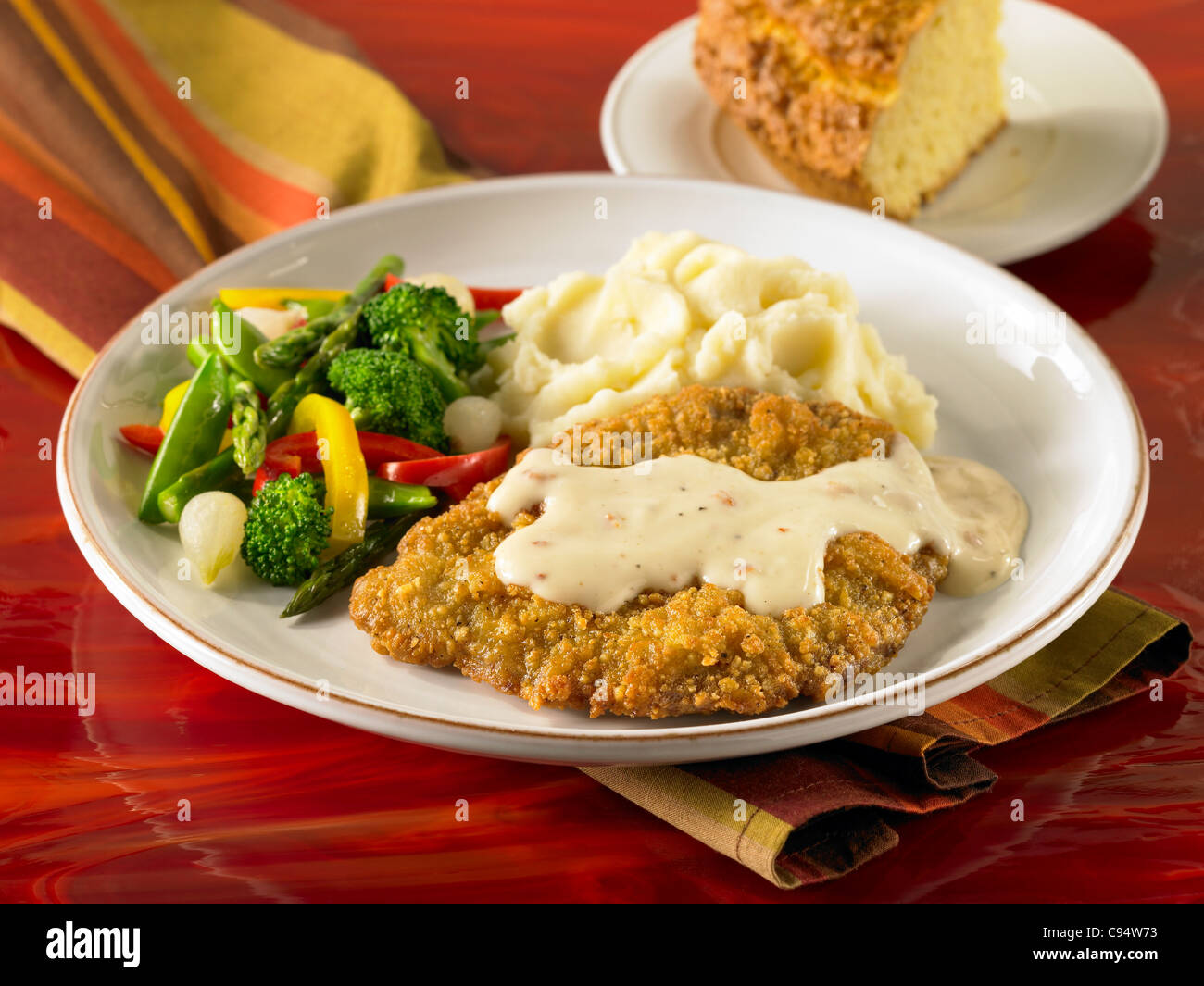 Steak frit au poulet avec sauce servi avec une purée de pommes de terre et légumes Banque D'Images