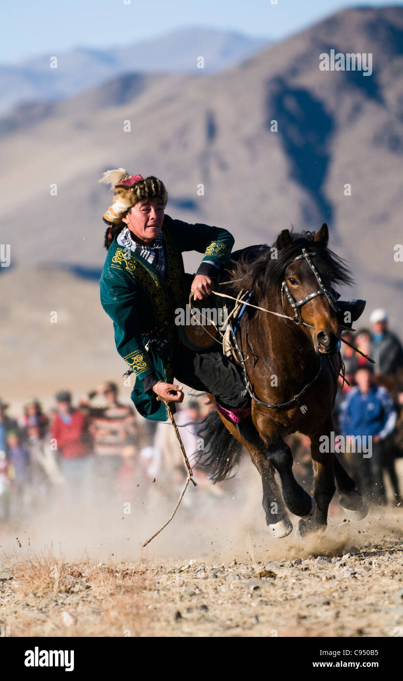 Un cavalier Kazakh lors d'un concours dans lequel alu Tengu ils doivent aller chercher un coin de terre en montant le cheval. Banque D'Images