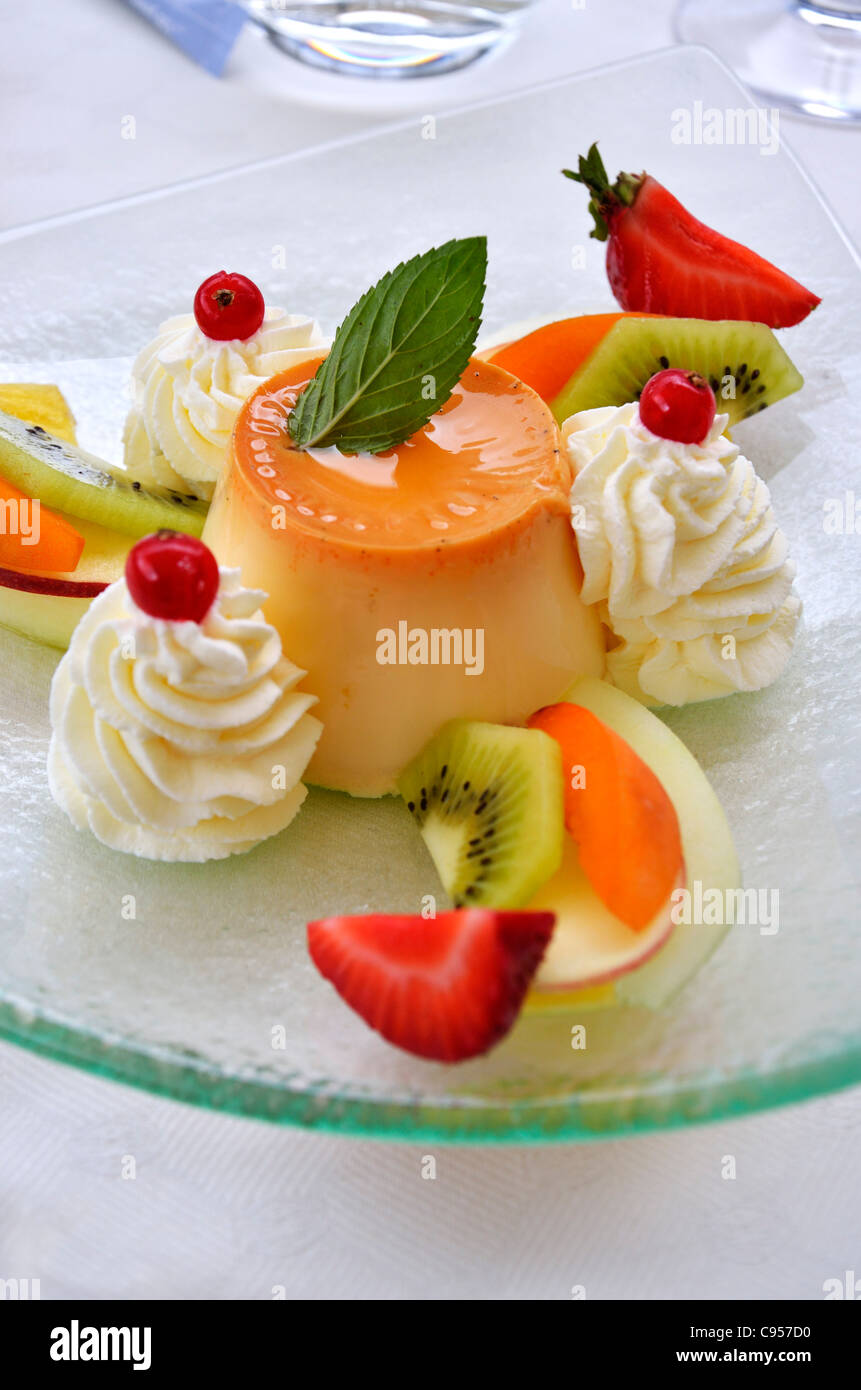 Caramel Flan dessert sur une table avec des fruits et de la crème. Banque D'Images