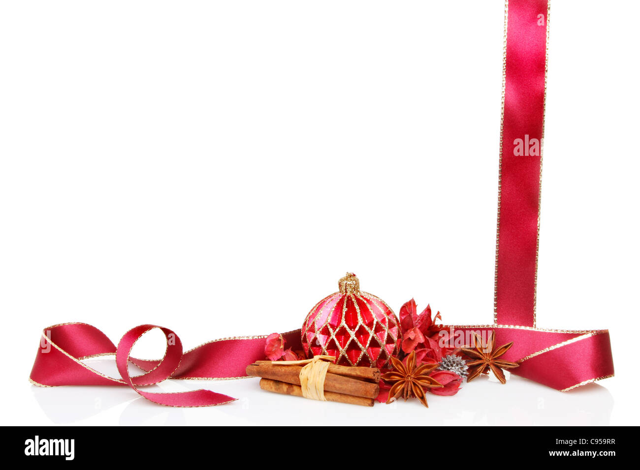 Sur le thème de Noël avec un cadre ou une bordure décoration babiole, pot-pourri, la cannelle, l'anis étoilé épices et un ruban rouge bordé d'or Banque D'Images