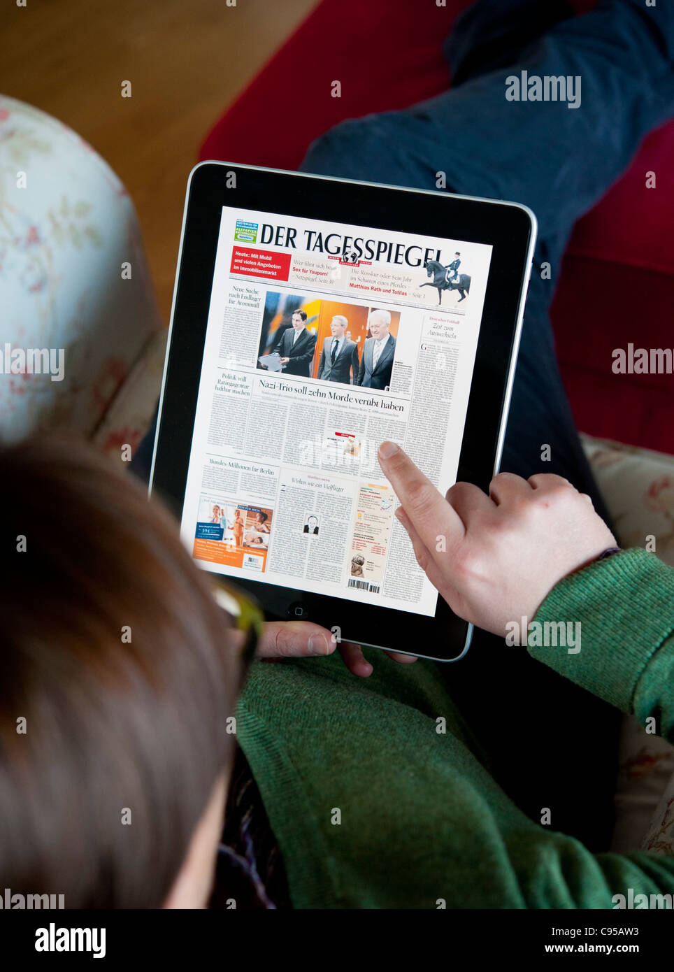 Femme à l'aide de l'ordinateur tablette iPad pour lire Digital edition of Der Tagesspiegel journal en Allemagne Banque D'Images