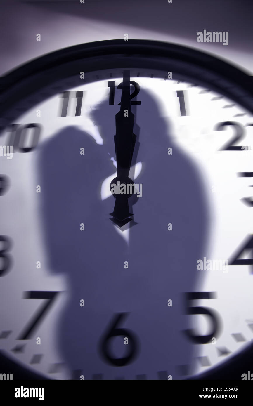 La silhouette du couple kissing superposée sur une horloge à minuit Banque D'Images