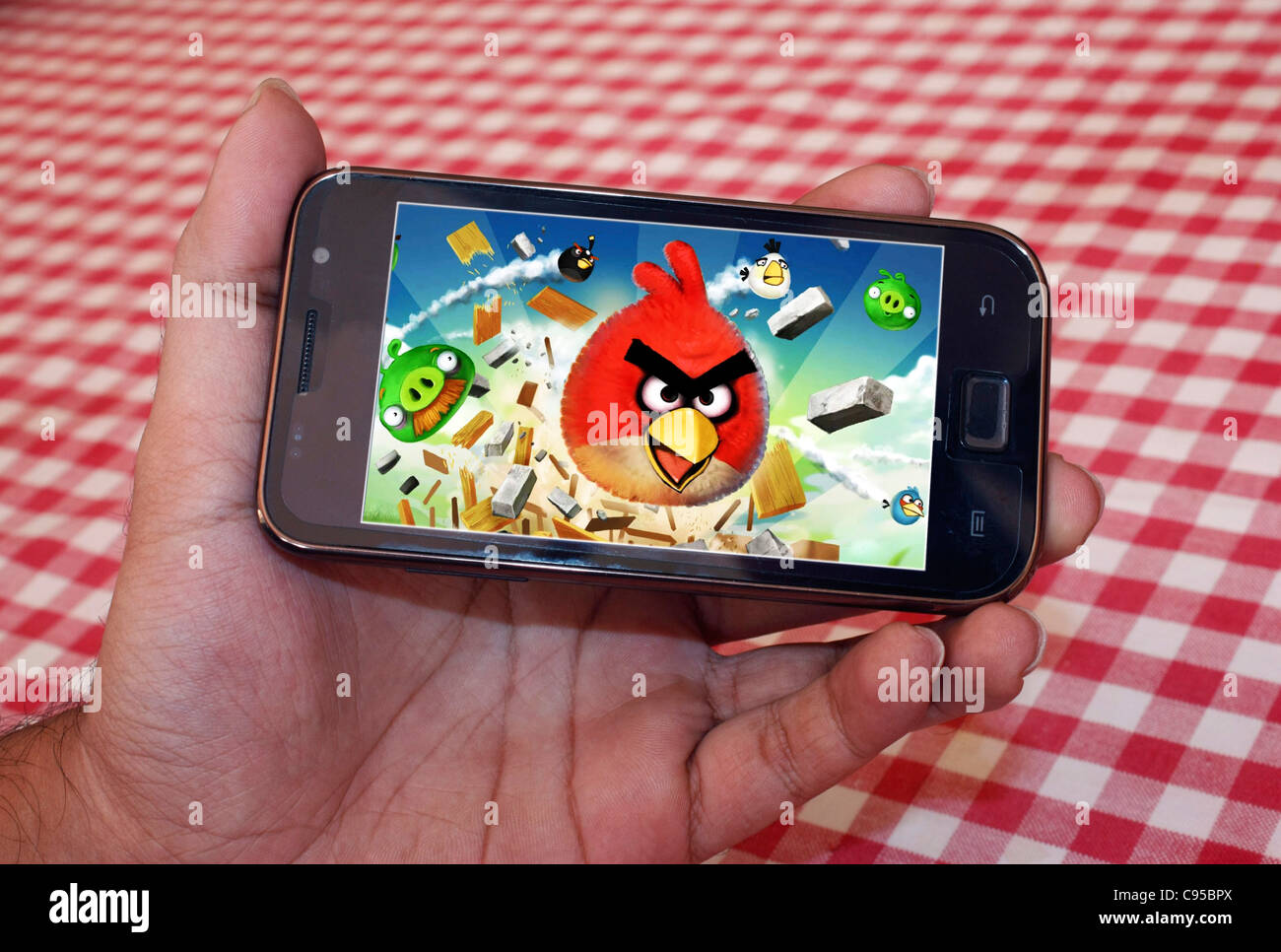 Un smartphone montrant l'écran de jeu Angry Birds a tenu dans les mains d'une personne Banque D'Images