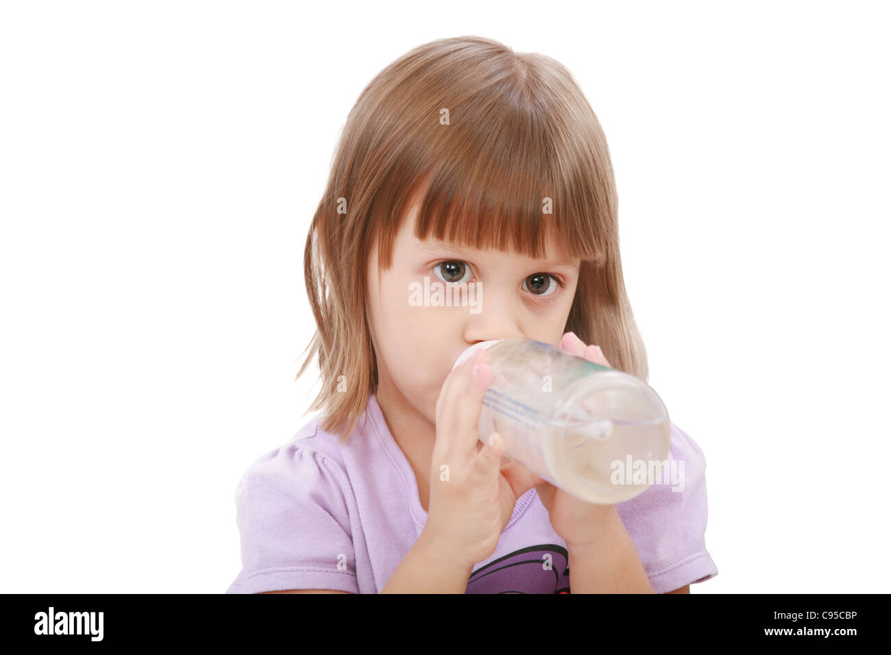 Petite fille de l'eau potable sa bouteille. Fond blanc Banque D'Images