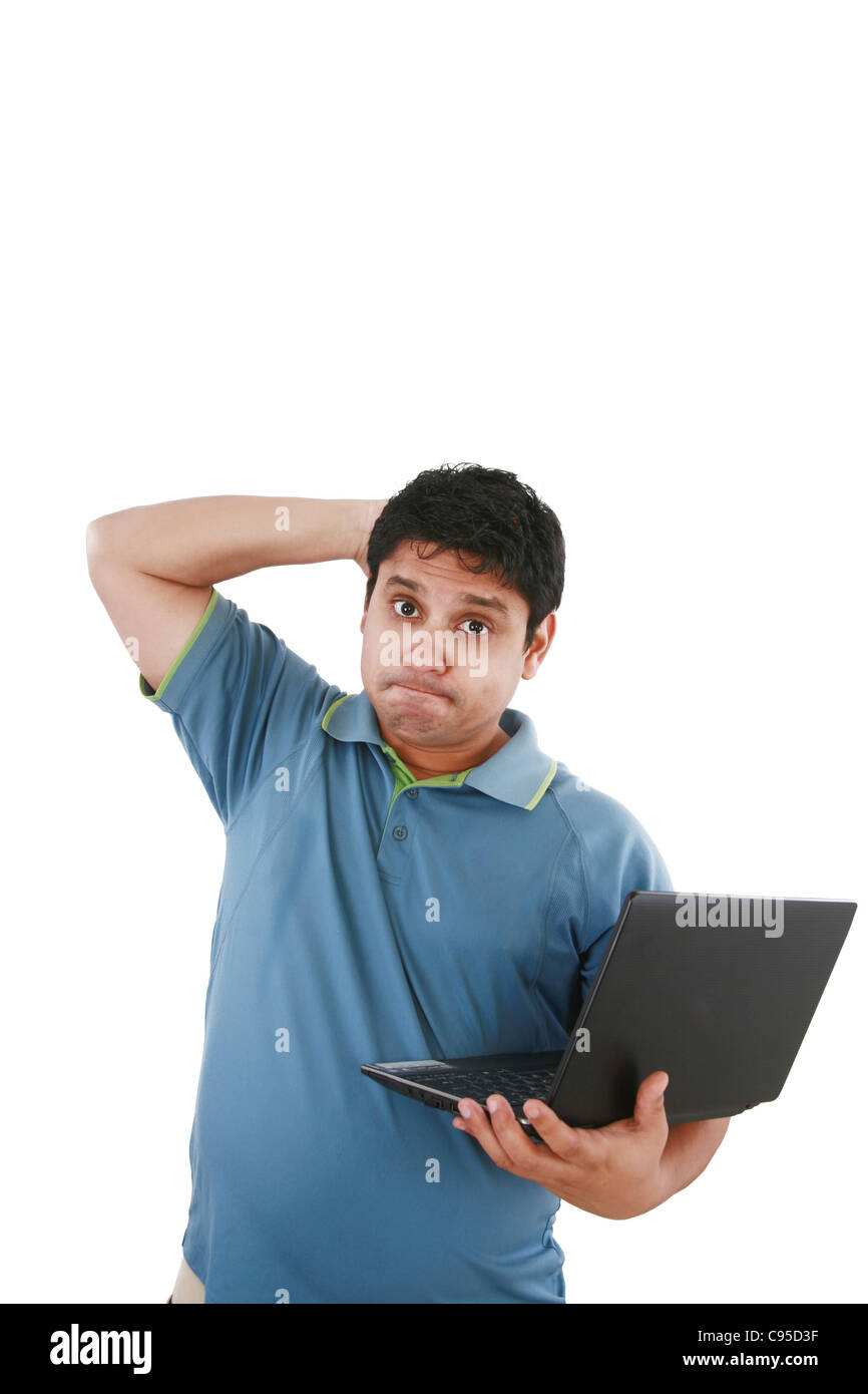 Les jeunes inquiète sman working on laptop Banque D'Images