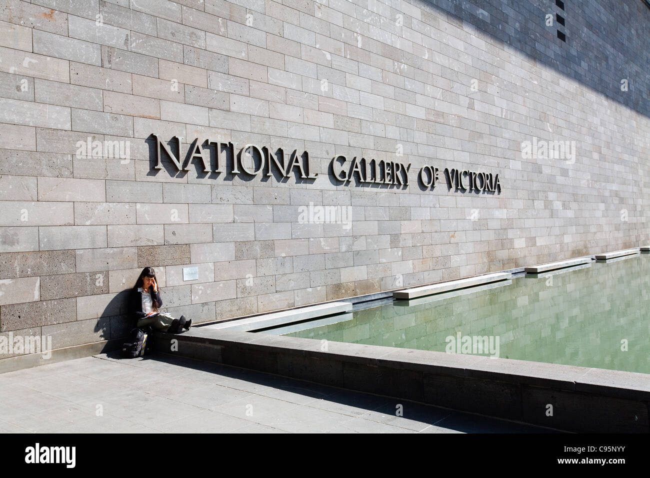 Femme assise à l'extérieur de la National Gallery of Victoria à Melbourne, Victoria, Australie Banque D'Images