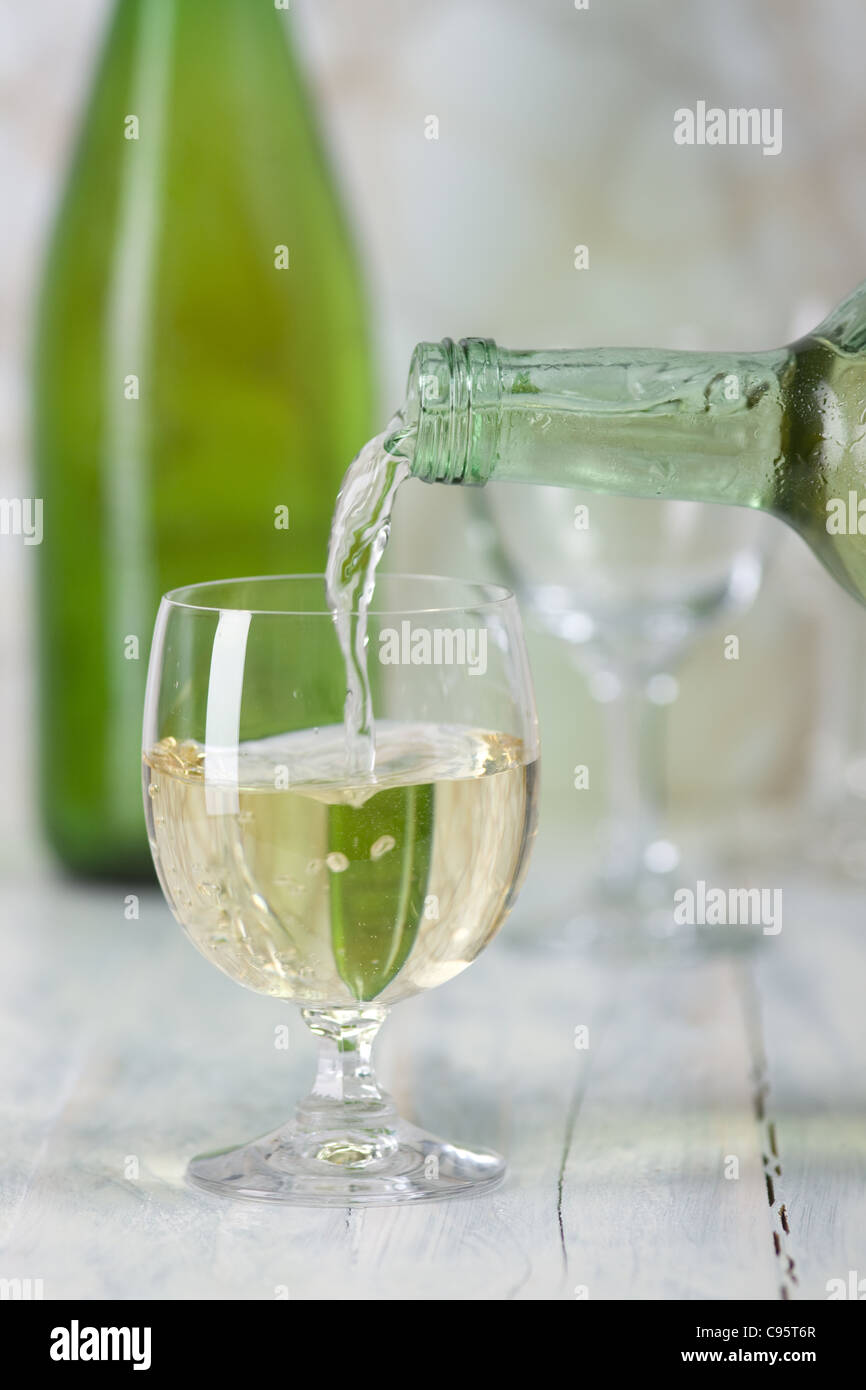 Le vin blanc est versé dans un verre. Banque D'Images