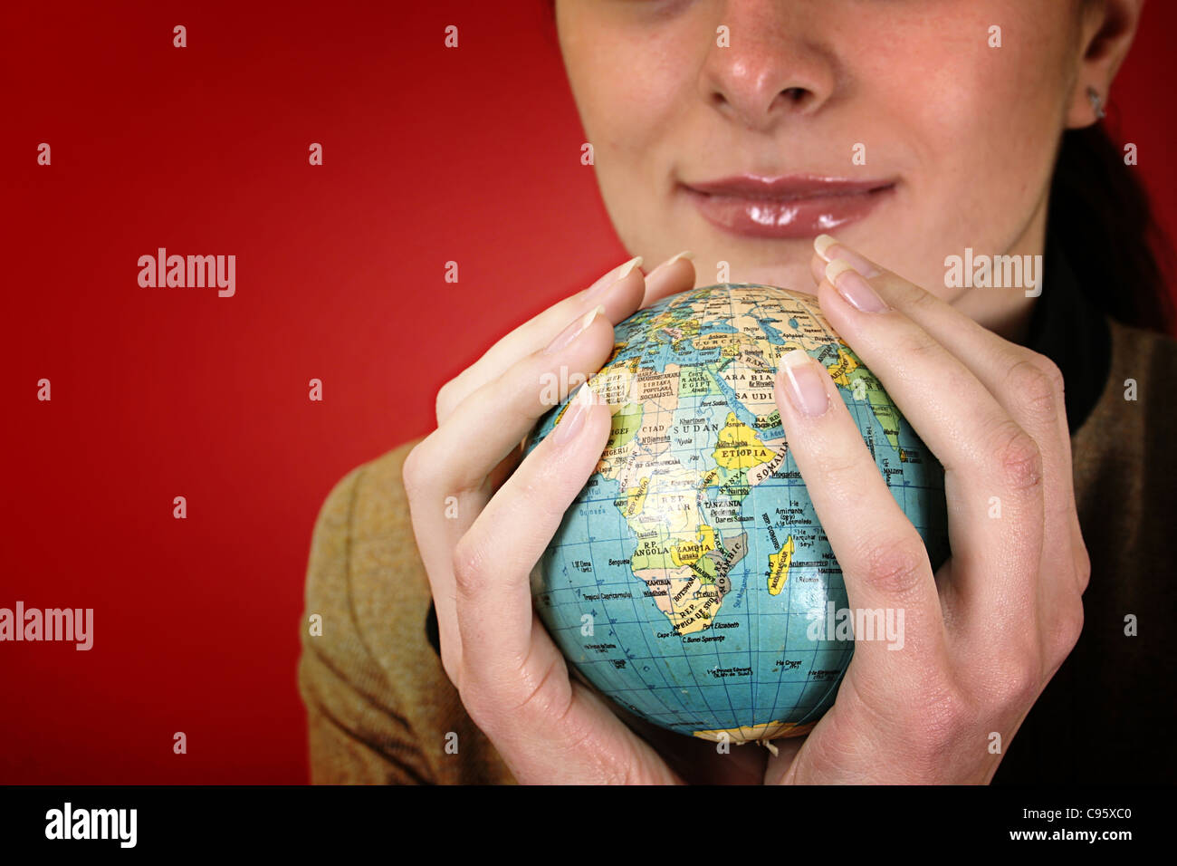 Globe in a girl's hands. Isolé sur red Banque D'Images