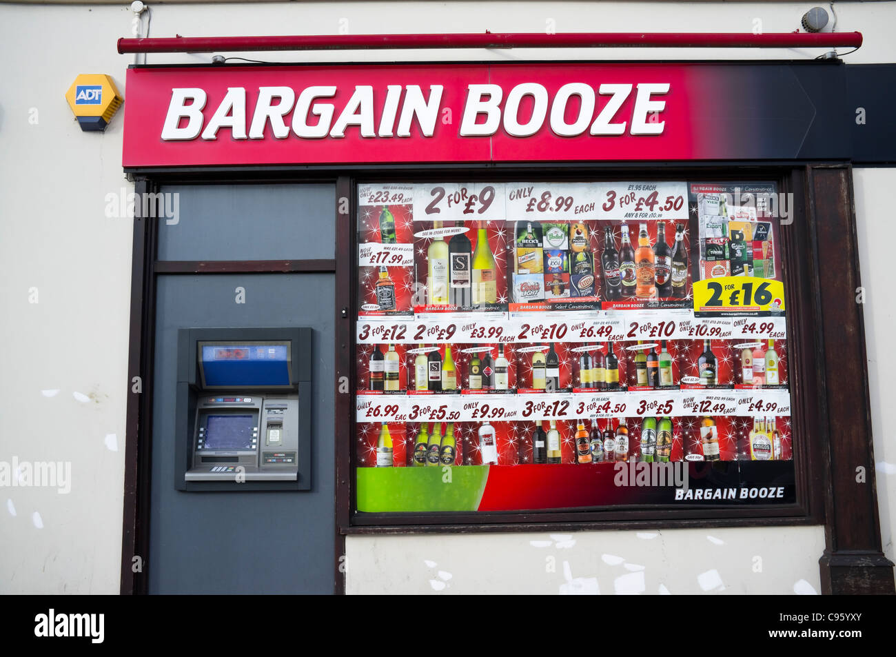 Bargain Booze Shop - avec une fenêtre d'affichage des annonces et offres spéciales très tentant - il y a également un distributeur automatique de billets. UK Banque D'Images