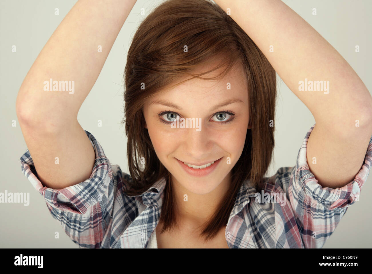 Adolescente avec ses bras levés au-dessus de sa tête. Banque D'Images