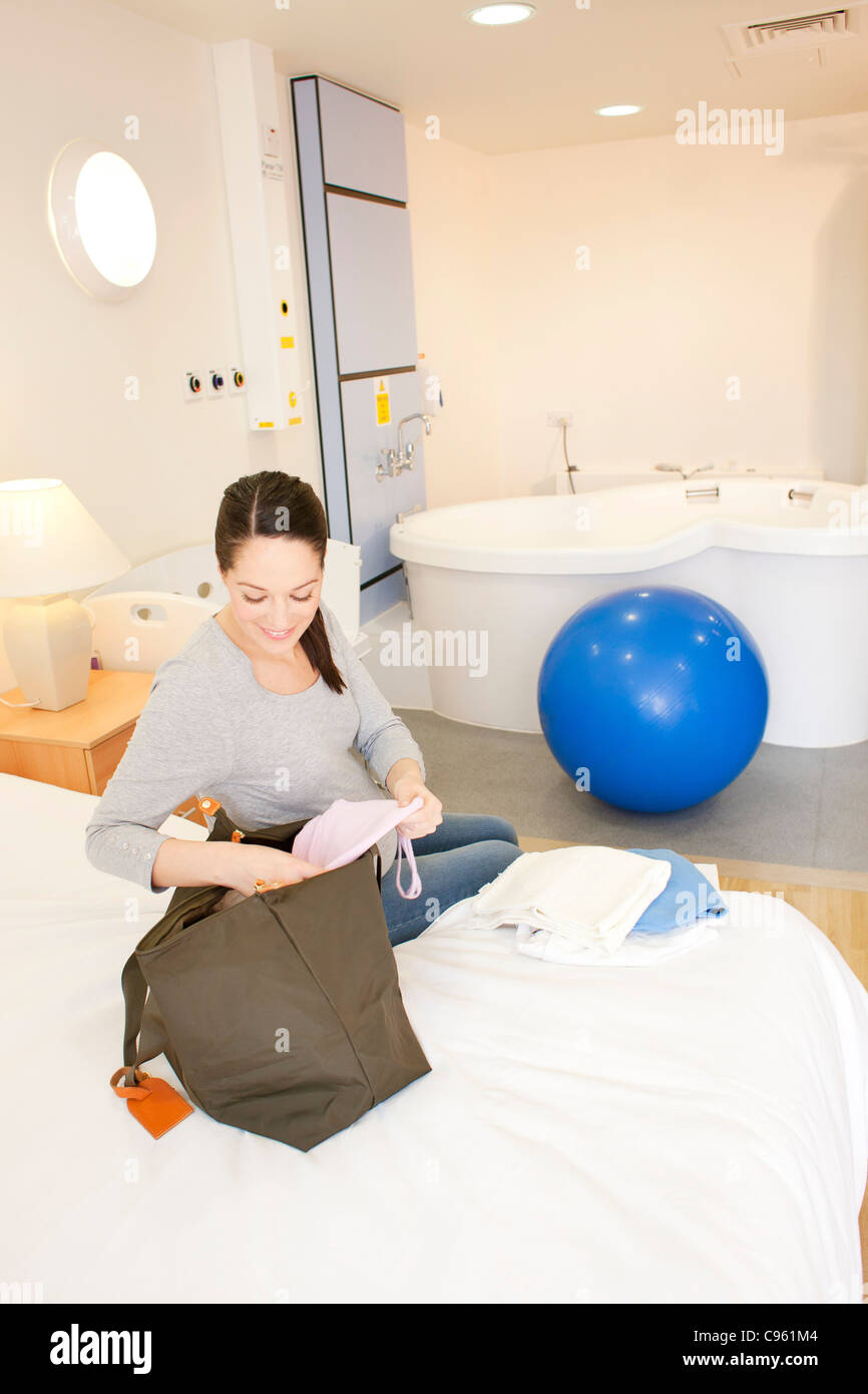 Centre de naissance. Déballage de la femme enceinte dans sa chambre à un centre de naissance. Banque D'Images