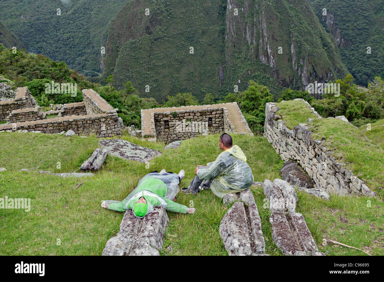 Les touristes à l'ancienne ruines Incas de Machu Picchu, site touristique le plus connu dans la région de montagnes des Andes, au Pérou. Banque D'Images