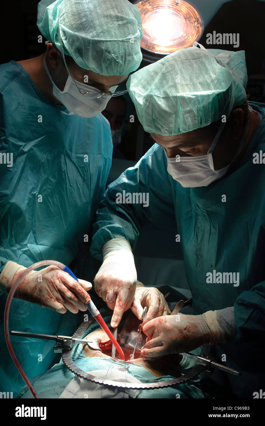 Médecins pratiquant la chirurgie la prostatectomie en salle d'opération Banque D'Images
