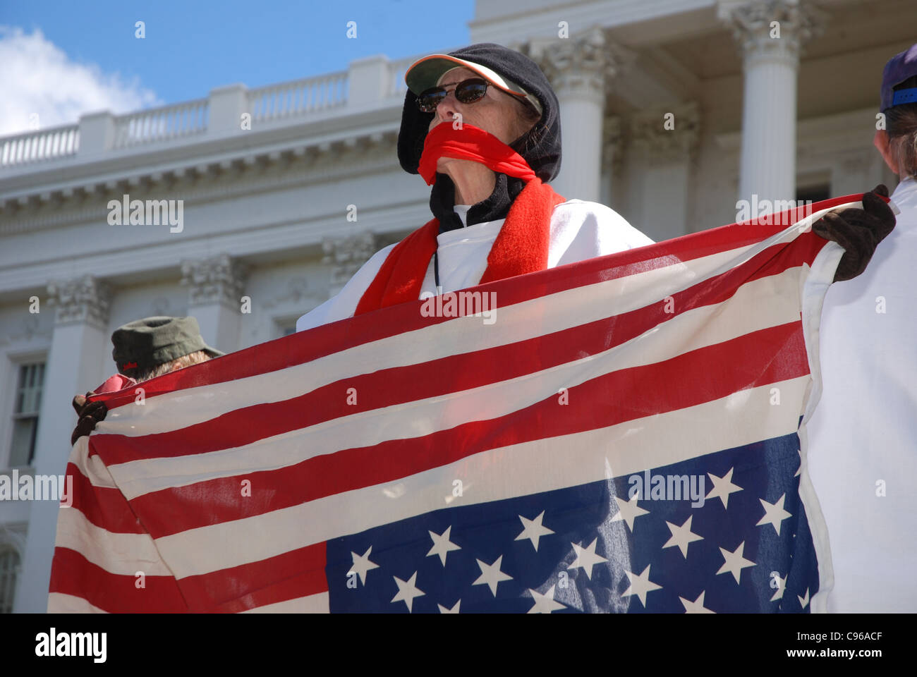 Manifestant la tenue d'un drapeau américain à l'envers avec foulard enroulé autour de la bouche Banque D'Images