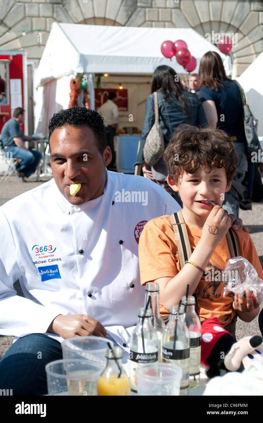 Le célèbre chef Michael Caines de manger des bonbons avec son fils à l'Exeter Food Festival. Banque D'Images
