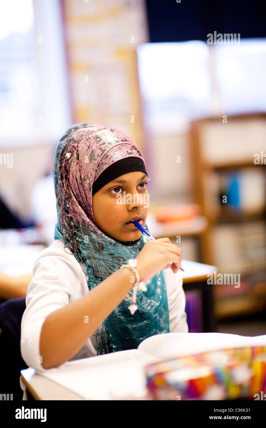 Une jeune femme musulmane, les enfants de l'école secondaire en classe, le Pays de Galles UK Banque D'Images