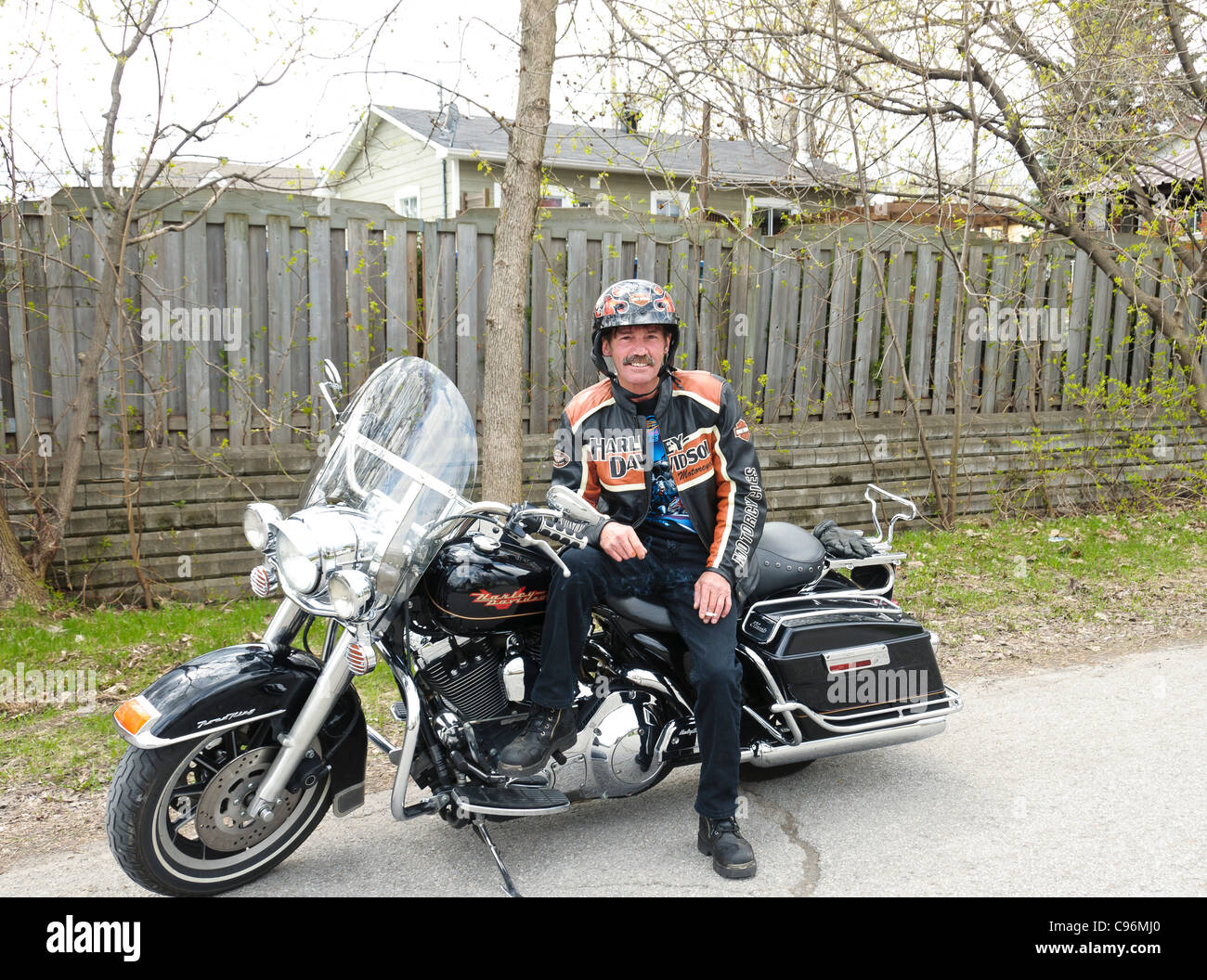 Biker montrant fièrement sa moto Harley Davidson sur son chemin à un rassemblement Banque D'Images