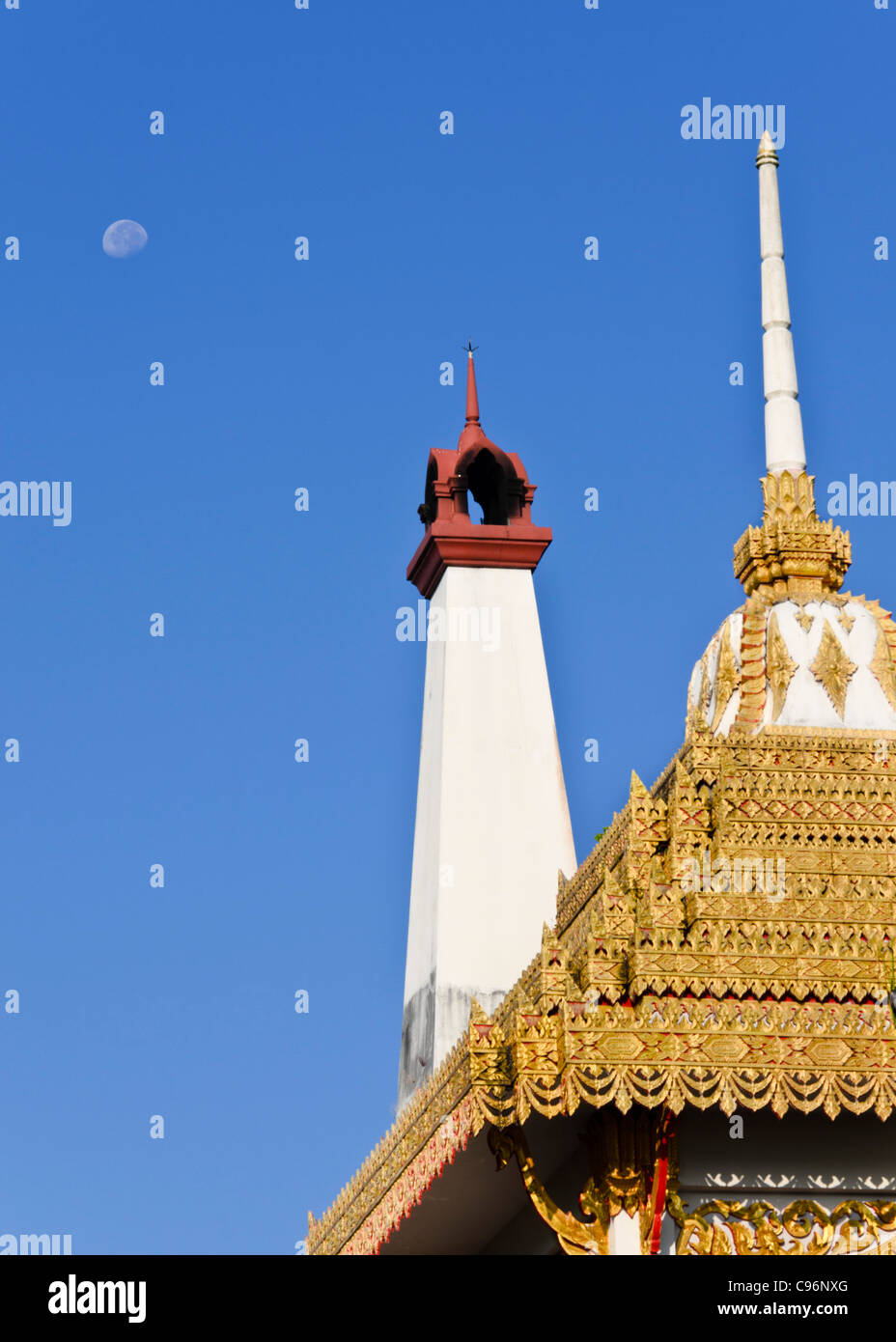 Crématorium bouddhiste avec des capacités d'or avec spire & blanc cheminée avec la lune dans ciel bleu clair dans le nord de la Thaïlande Banque D'Images
