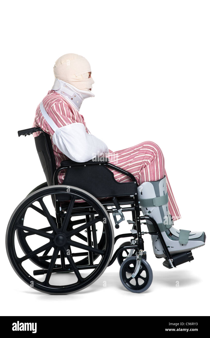 Photo d'un homme avec diverses blessures portant pyjames rayé et assis dans un fauteuil roulant. Banque D'Images