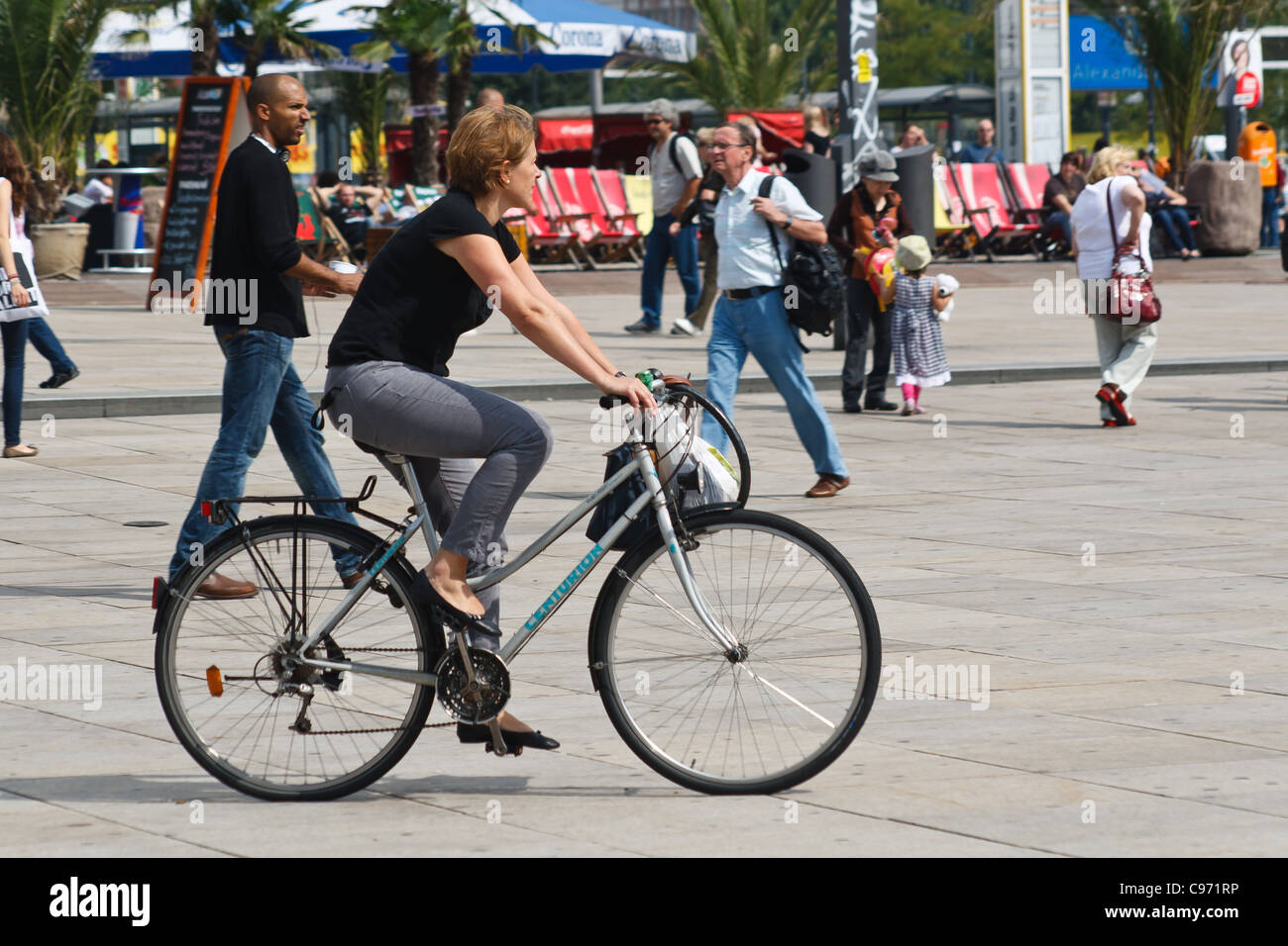Femme sur un vélo. Alexanderplatz, Berlin, Allemagne. Banque D'Images
