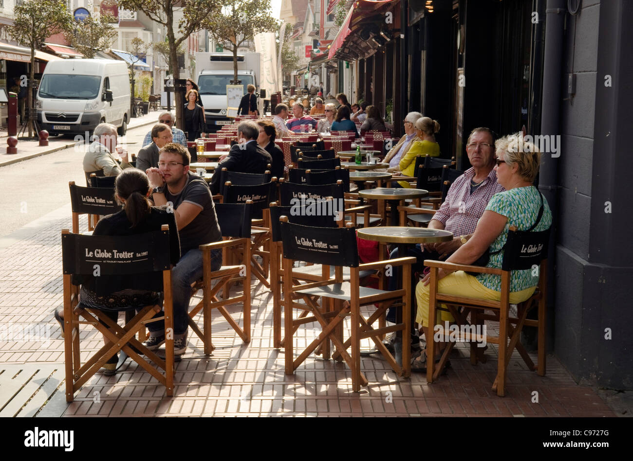 Les gens assis se détendre boire et manger dans un café de la rue chaussée français extérieur à Le touquet France Banque D'Images