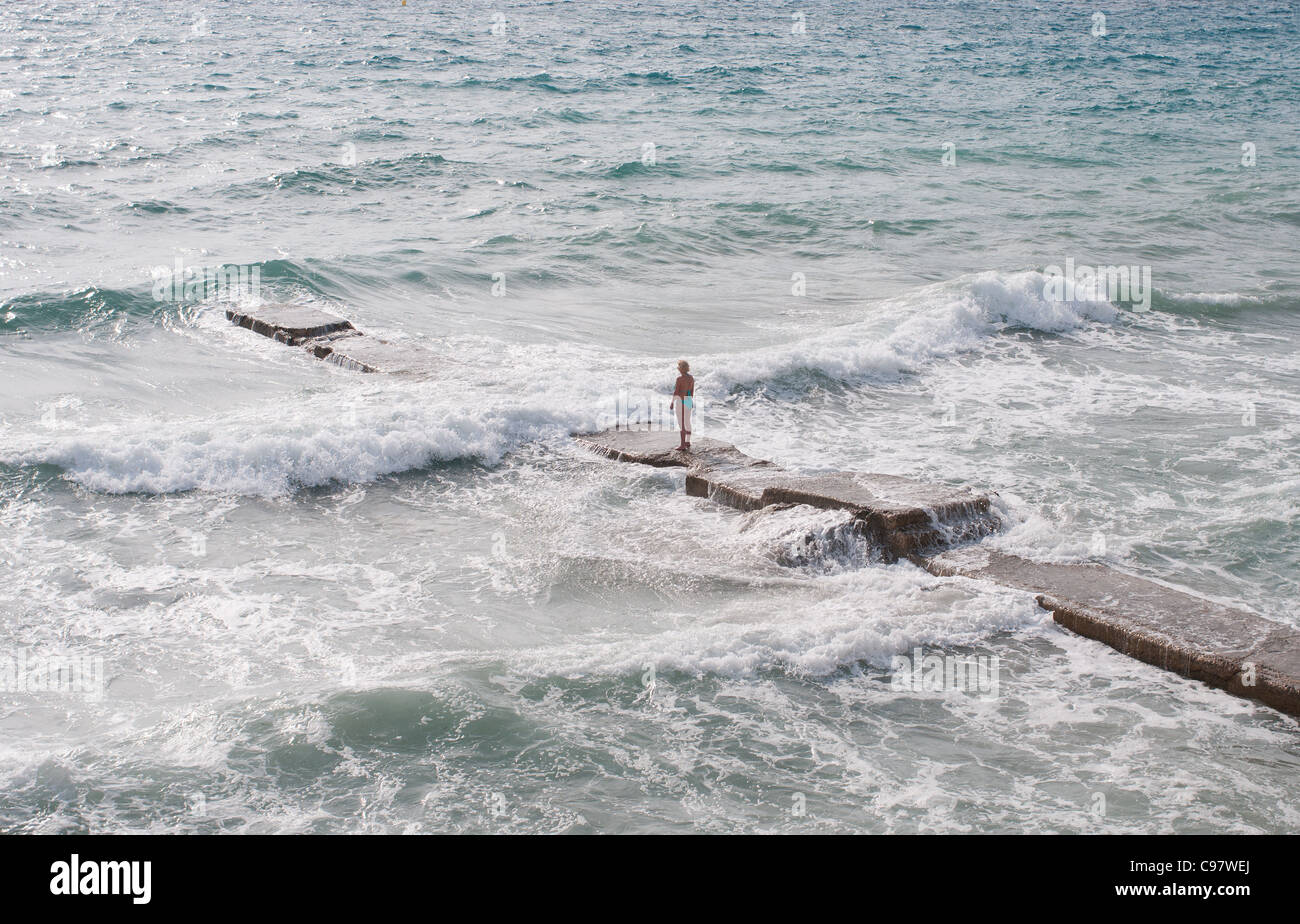 La seule figure d'une femme dans un bikini fait face à la mer sur la plage de Camp de Mar, à proximité de Port d'Andratx de Majorque Banque D'Images