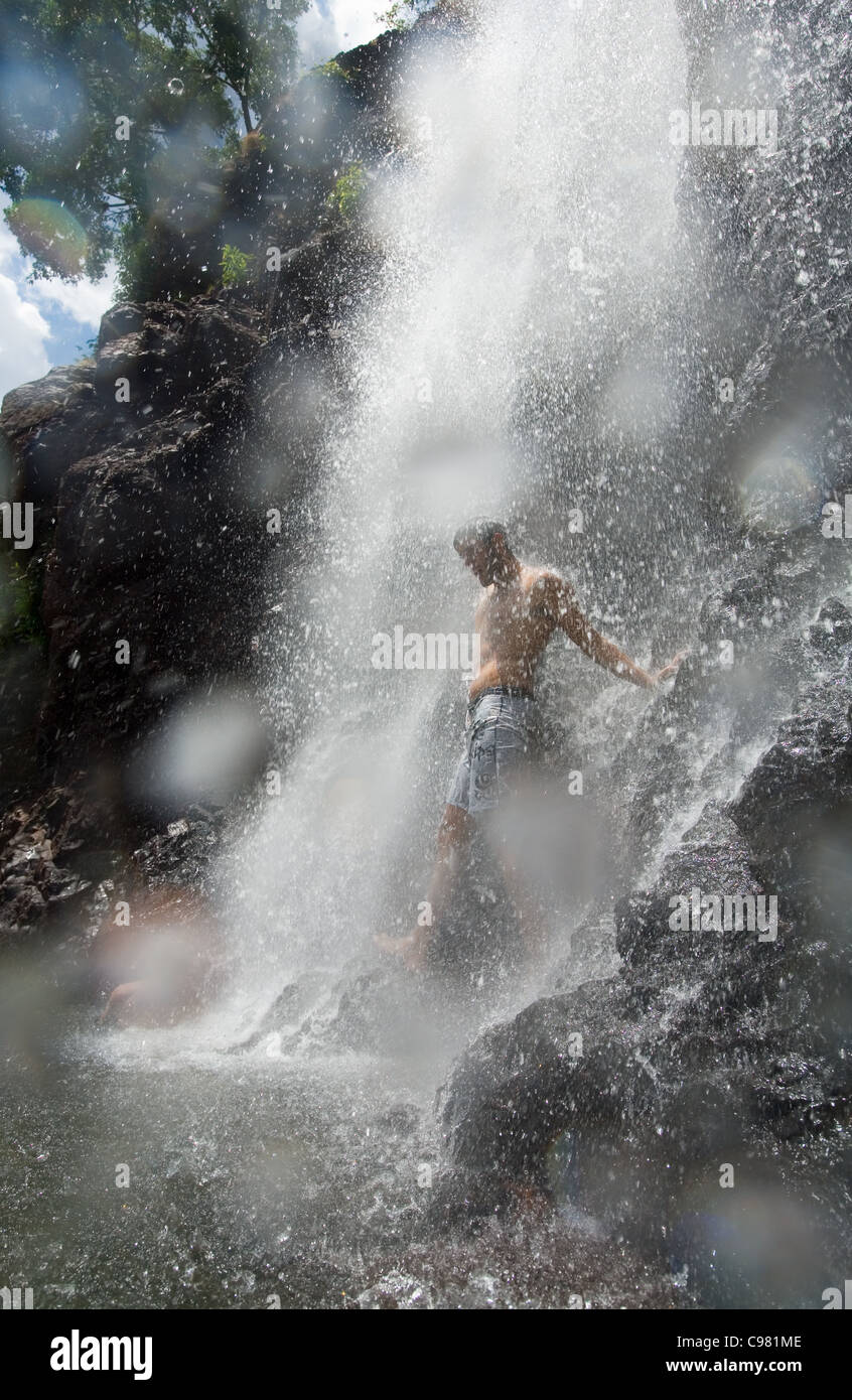Homme debout à la base d'une cascade. Wangi Falls, Litchfield National Park, Territoire du Nord, Australie Banque D'Images
