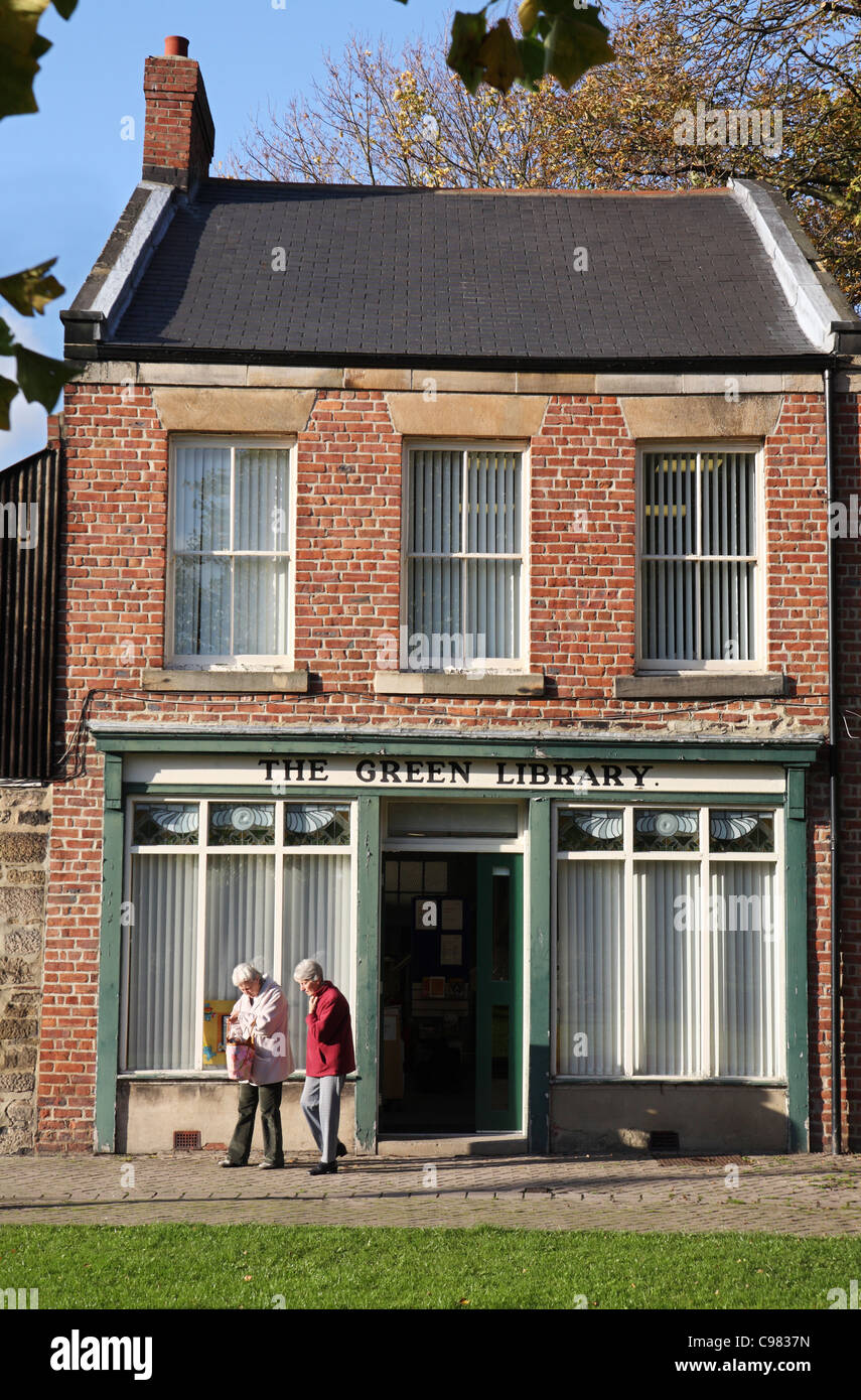 Les deux femmes quittent la bibliothèque publique de Washington, Vert Village Green, Angleterre du Nord-Est, Royaume-Uni Banque D'Images