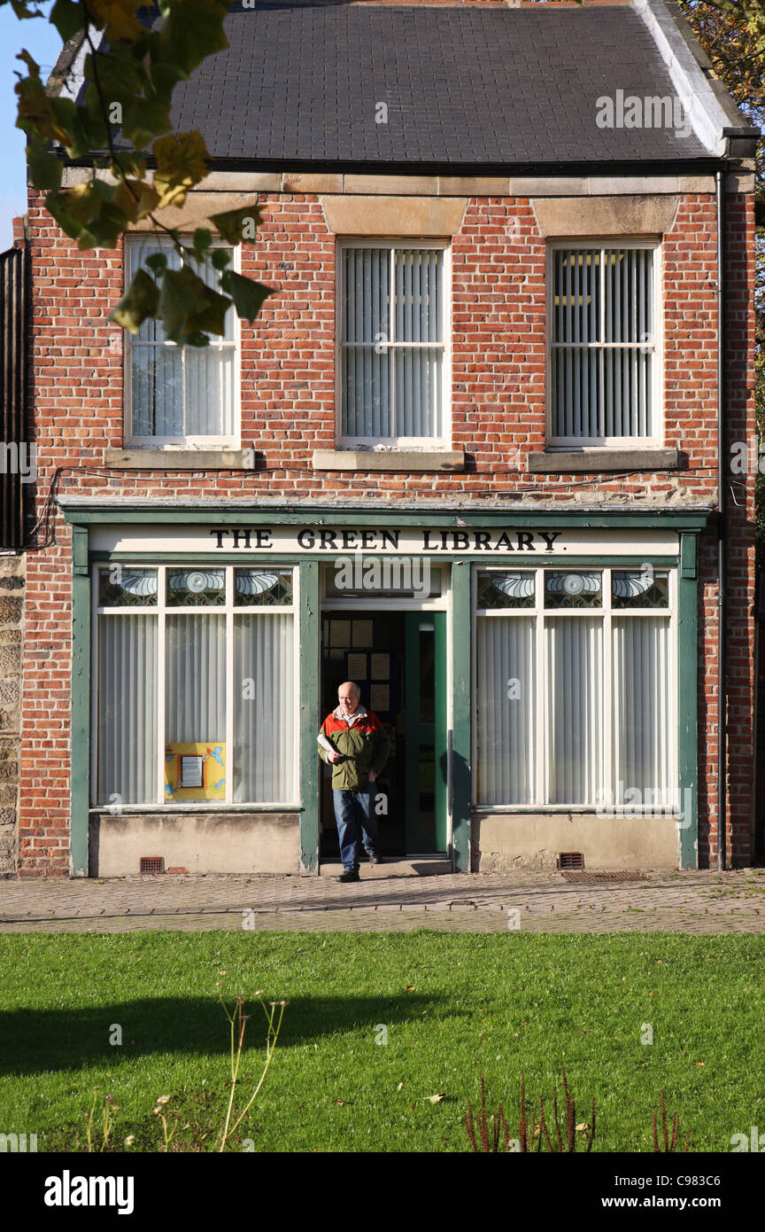 Homme mûr de quitter le Vert La bibliothèque publique, Washington Village Green, Angleterre du Nord-Est, Royaume-Uni Banque D'Images
