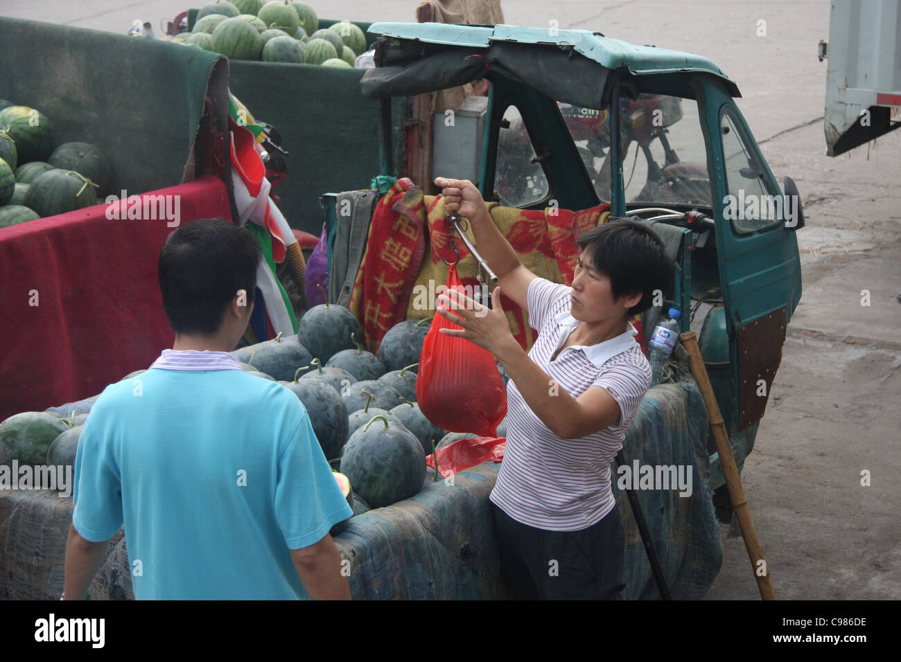 Les pastèques de pesage avec une balance, Farmer's Market, Changsha, Chine Banque D'Images